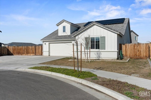 view of front of house featuring a garage and solar panels