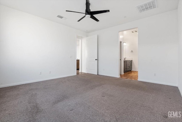 unfurnished bedroom with ceiling fan, light carpet, and ensuite bath