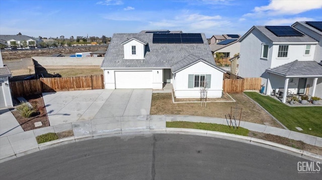 view of front of property with a garage and solar panels