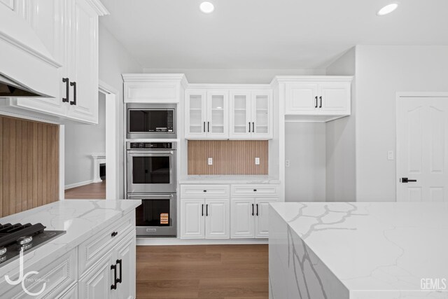 11009 Bright Water Way, Bakersfield, CA 93311 - kitchen with custom range hood, appliances with stainless steel finishes, white cabinets, recessed lighting, and glass insert cabinets