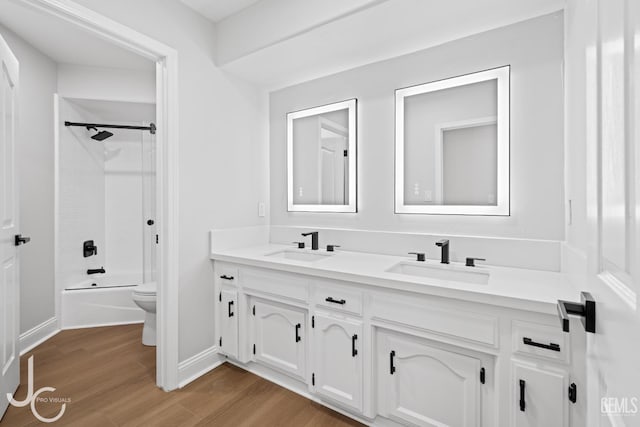 11009 Bright Water Way, Bakersfield, CA 93311 - bathroom featuring toilet, double vanity, wood finished floors, washtub / shower combination, and baseboards
