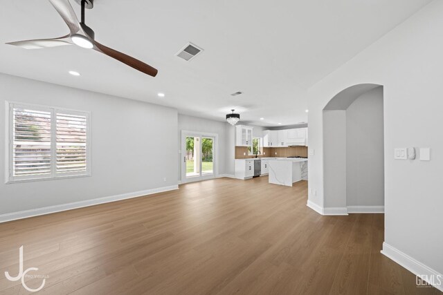 11009 Bright Water Way, Bakersfield, CA 93311 - unfurnished living room with a ceiling fan, recessed lighting, baseboards, arched walkways, and wood finished floors