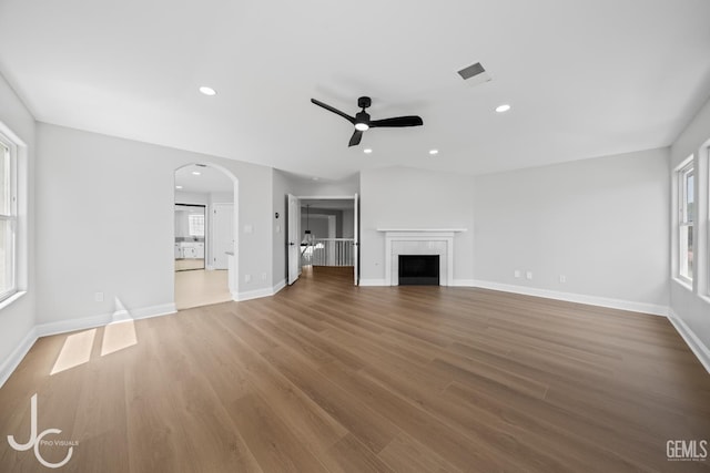 11009 Bright Water Way, Bakersfield, CA 93311 - unfurnished living room featuring a ceiling fan, healthy amount of natural light, wood finished floors, arched walkways, and recessed lighting