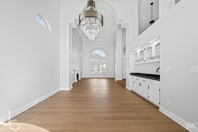 11009 Bright Water Way, Bakersfield, CA 93311 - foyer featuring a towering ceiling, a chandelier, baseboards, light wood-type flooring, and crown molding