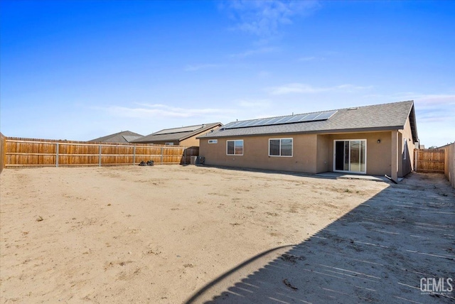 rear view of house featuring solar panels