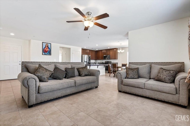 living room with ceiling fan with notable chandelier