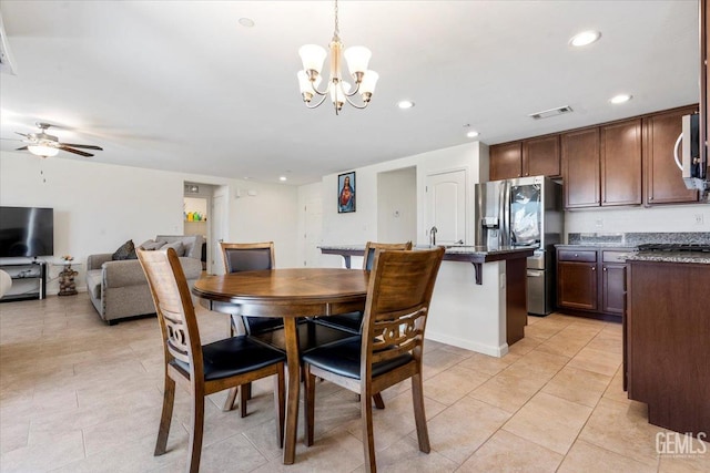 tiled dining room with ceiling fan with notable chandelier