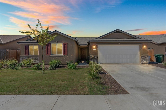 ranch-style house featuring a garage and a lawn