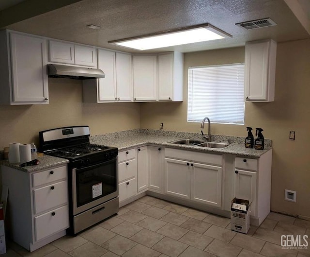 kitchen with sink, stainless steel range with gas stovetop, white cabinets, and light stone counters