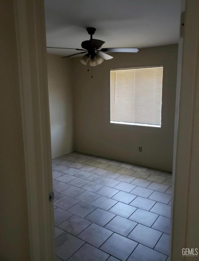 unfurnished room with ceiling fan and light tile patterned flooring