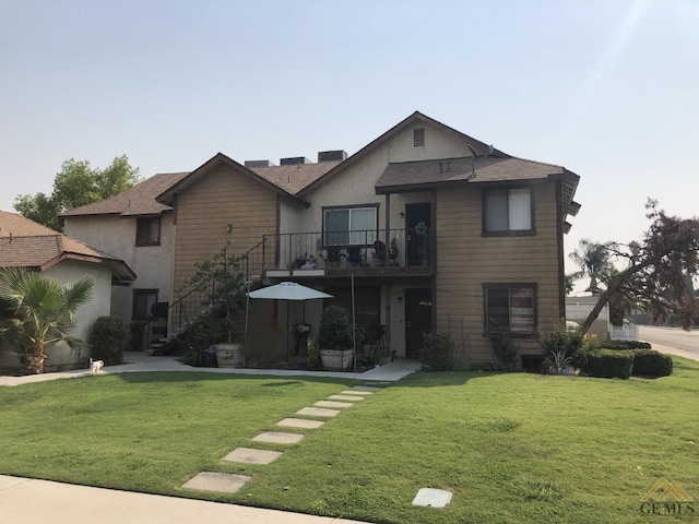 front of property featuring a front yard and a balcony