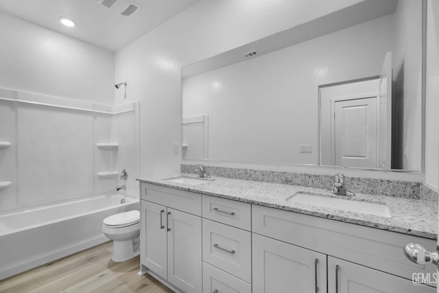 full bathroom with hardwood / wood-style floors, shower / bathing tub combination, vanity, and toilet