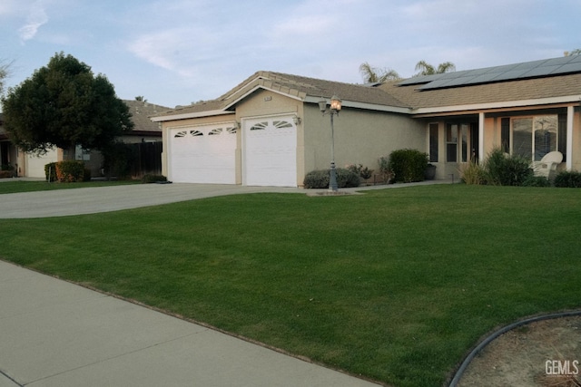 view of front of home featuring a garage, a front yard, and solar panels