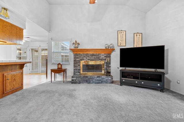 living room featuring a brick fireplace, ceiling fan, high vaulted ceiling, and carpet flooring