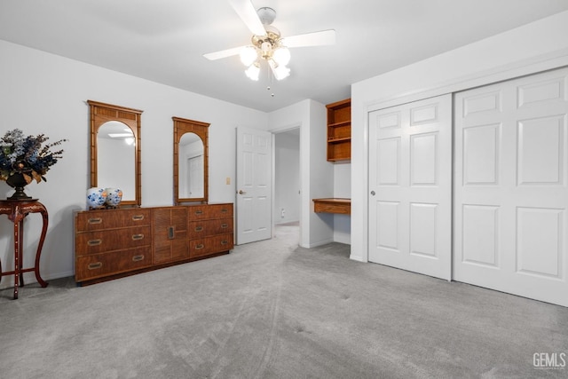 bedroom with carpet floors, a closet, ceiling fan, and built in desk