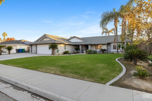 view of front of home featuring a garage, driveway, a front lawn, and stone siding