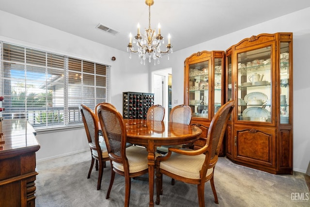 dining space featuring an inviting chandelier, baseboards, visible vents, and light colored carpet