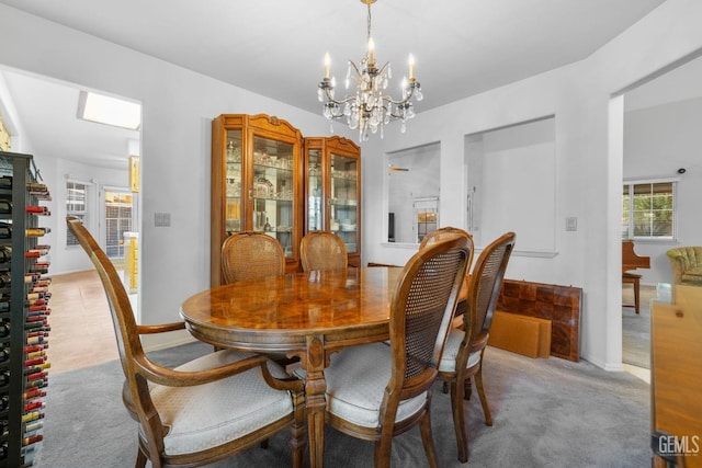 carpeted dining space featuring a notable chandelier