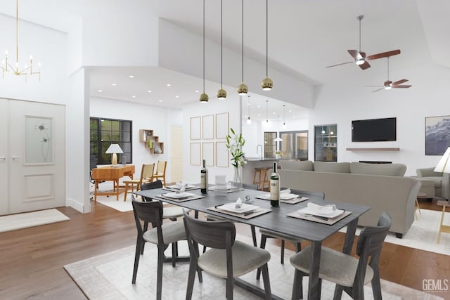 dining room with recessed lighting, an inviting chandelier, a high ceiling, and wood finished floors