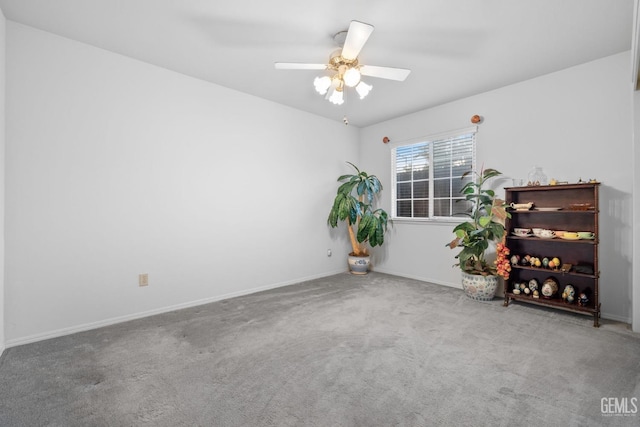 spare room with carpet, a ceiling fan, and baseboards