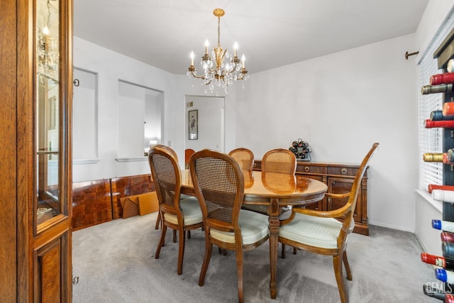 dining space featuring a chandelier, carpet floors, and baseboards