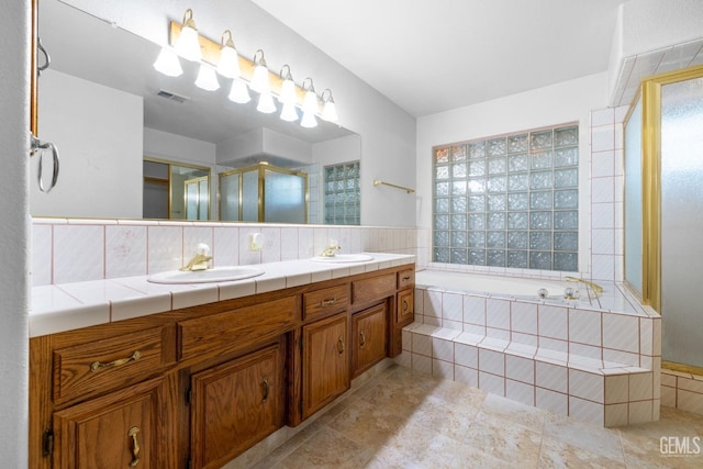 full bath with double vanity, a stall shower, a sink, and visible vents