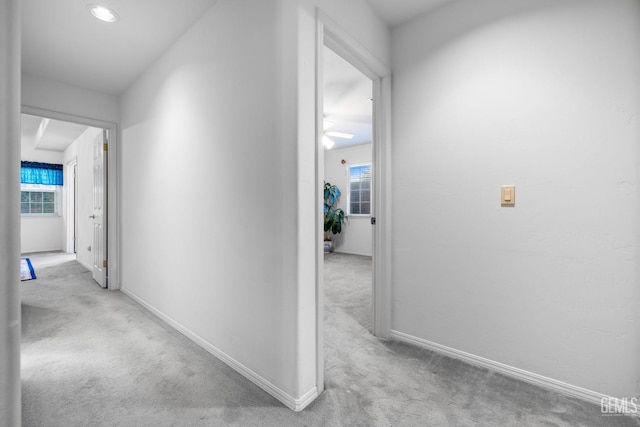 corridor featuring carpet flooring and baseboards