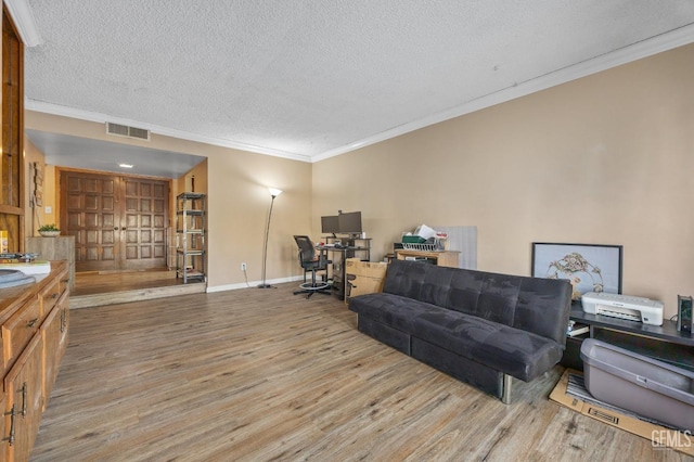 office space featuring ornamental molding, light hardwood / wood-style floors, and a textured ceiling