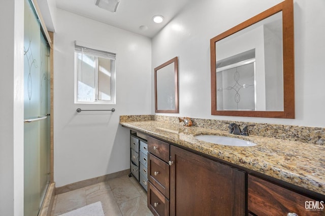 bathroom featuring vanity, a shower with shower door, and tile patterned floors