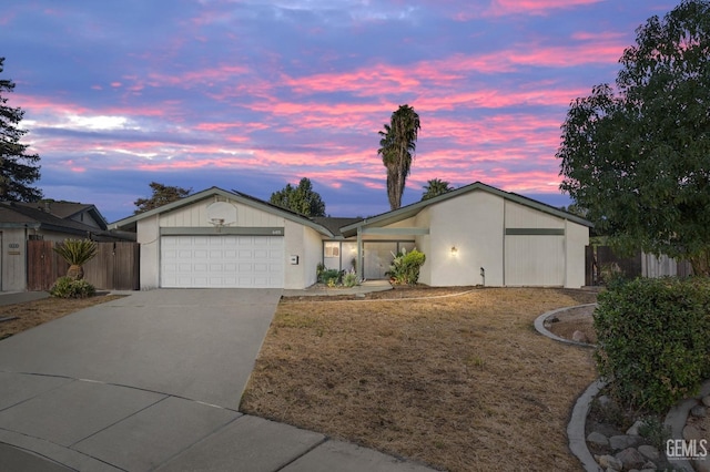 single story home featuring a garage and a lawn