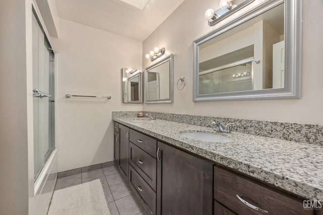 bathroom with tile patterned flooring, vanity, and shower / bath combination with glass door