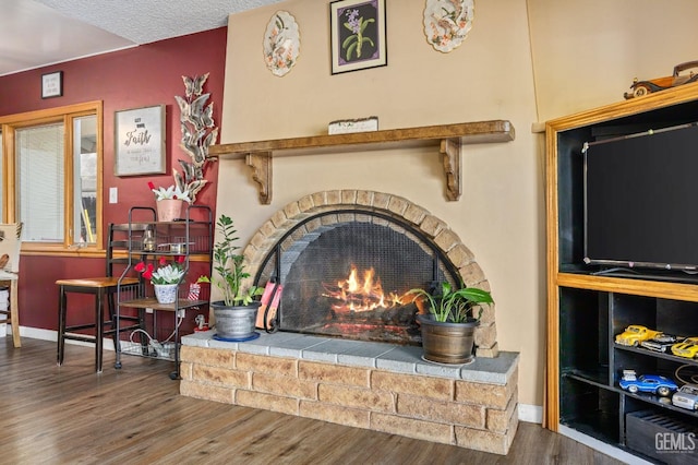 details featuring wood-type flooring, a fireplace, and a textured ceiling