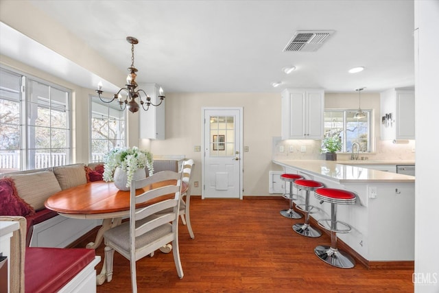 dining room with breakfast area, an inviting chandelier, sink, and hardwood / wood-style floors