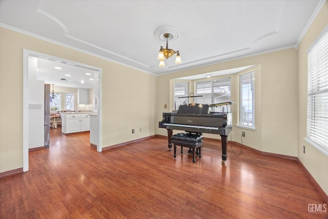 miscellaneous room featuring crown molding, hardwood / wood-style flooring, and a chandelier