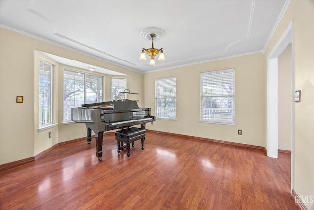 miscellaneous room featuring a notable chandelier, ornamental molding, and hardwood / wood-style floors