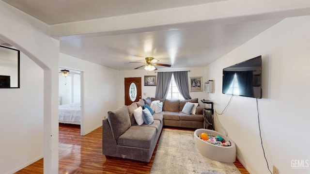 living room featuring hardwood / wood-style flooring, ceiling fan, and a wall unit AC