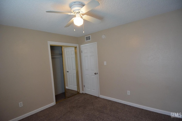 unfurnished bedroom featuring ceiling fan, carpet floors, a closet, and a textured ceiling