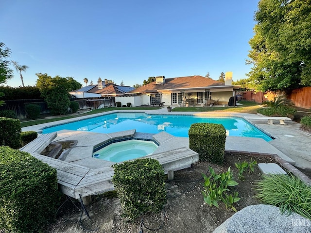 view of swimming pool featuring a diving board, an in ground hot tub, a fenced in pool, and a fenced backyard