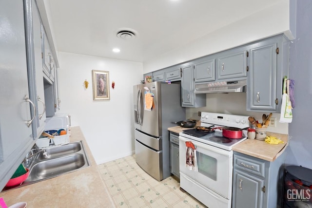 kitchen featuring light floors, stainless steel fridge with ice dispenser, under cabinet range hood, white range with electric stovetop, and gray cabinetry