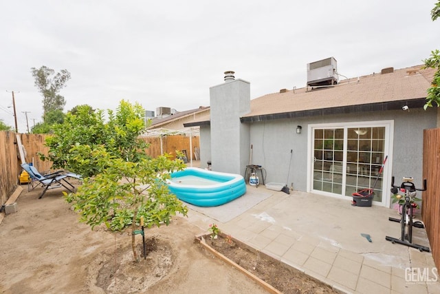 exterior space featuring a patio area, central air condition unit, and a fenced backyard