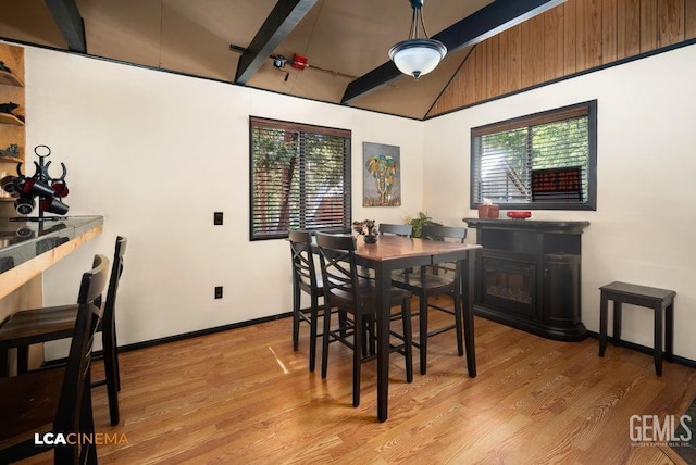 dining area with lofted ceiling, light wood-type flooring, and a wealth of natural light