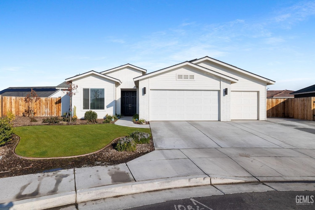 ranch-style house with a garage and a front yard