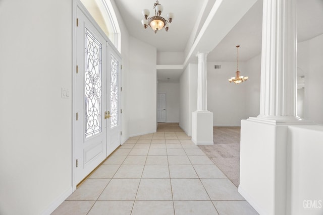 entryway featuring an inviting chandelier, decorative columns, and a wealth of natural light