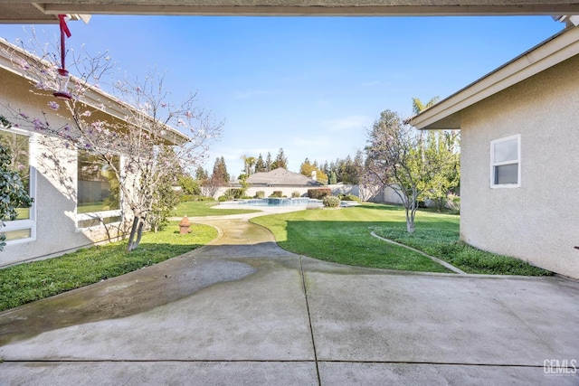 view of yard featuring fence, an outdoor pool, and a patio