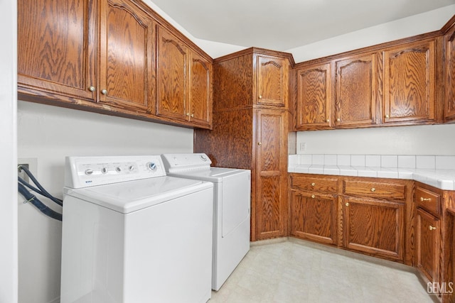 washroom featuring cabinet space, separate washer and dryer, and light floors