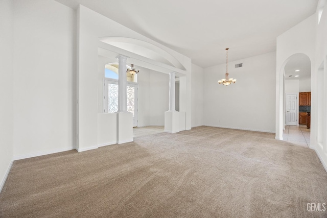 empty room featuring light carpet, baseboards, visible vents, and a notable chandelier