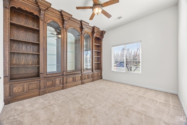 unfurnished room featuring a ceiling fan, light carpet, visible vents, and baseboards