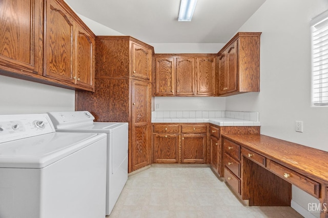 washroom with cabinet space, washing machine and dryer, and light floors