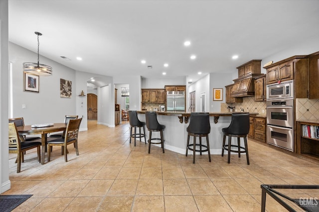 11416 Queensbury Dr, Bakersfield, CA 93312 - kitchen with built in appliances, tasteful backsplash, a kitchen bar, recessed lighting, and dark countertops