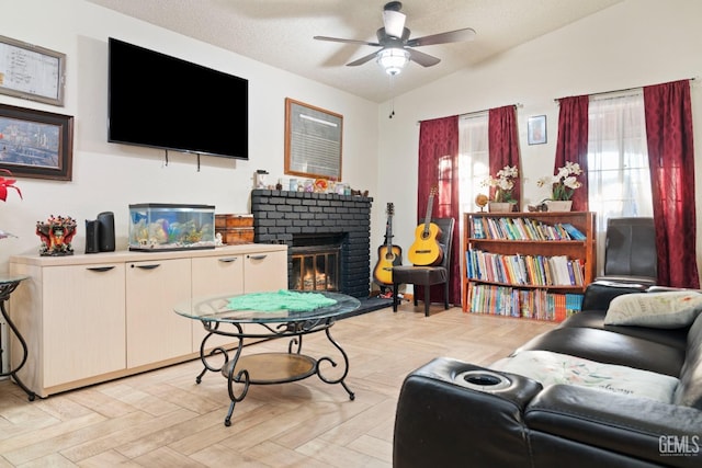 living room with lofted ceiling, a brick fireplace, a textured ceiling, ceiling fan, and light parquet flooring